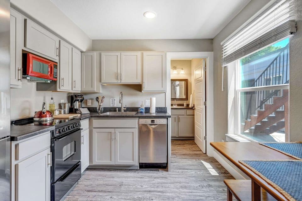 Enjoy the convenience of a well-stocked kitchen with modern appliances, natural light, and easy access to the bathroom just beyond.

