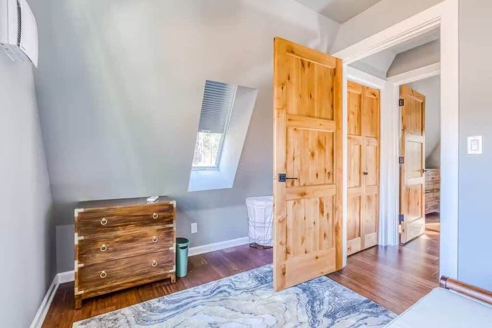 right and airy bedroom with slanted ceilings, skylight, and warm wood accents—clean, simple, and perfect for a peaceful stay.