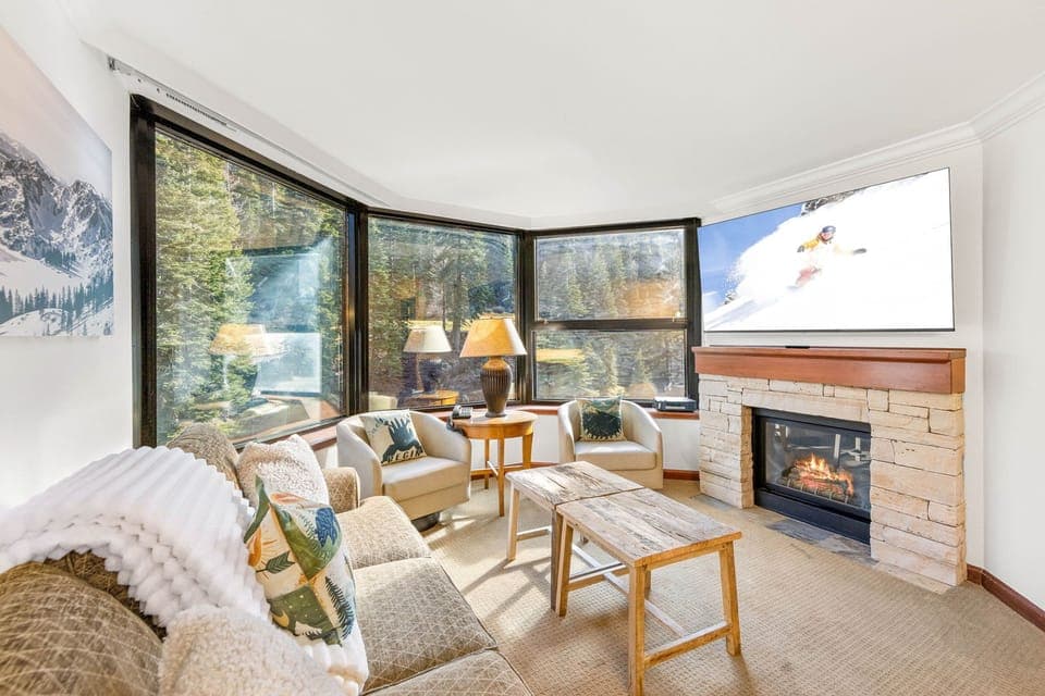 Unwind by your crackling fireplace while soaking in stunning forest views through expansive windows in this cozy mountain retreat.