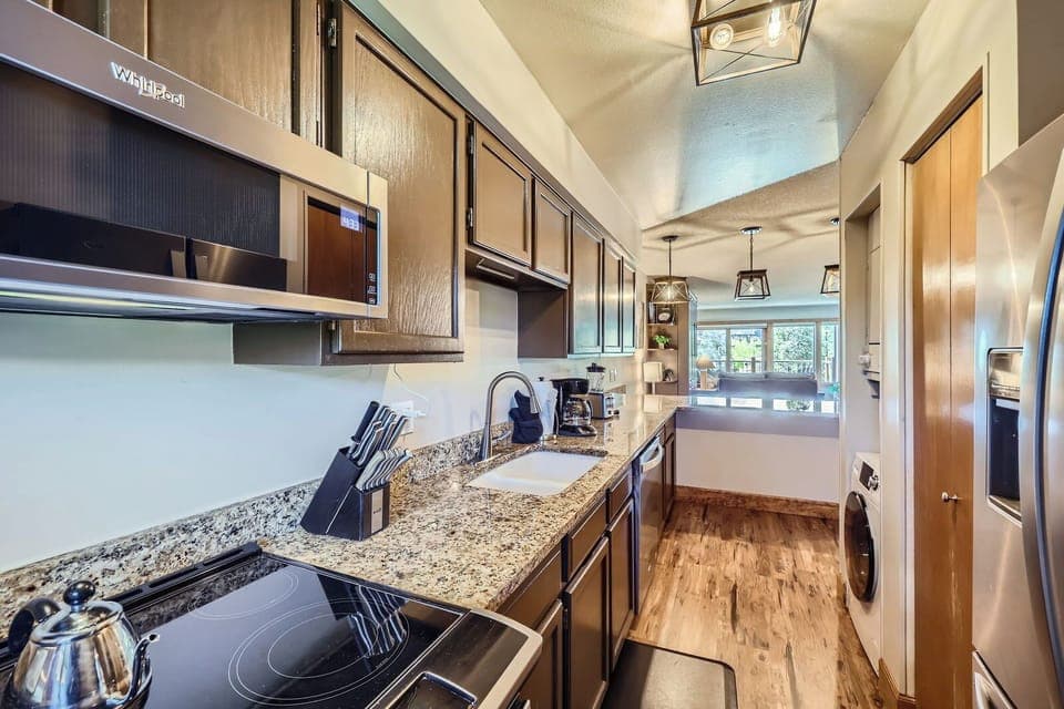 Fully equipped galley-style kitchen with granite countertops, modern appliances, and everything you need to cook and dine in comfort.