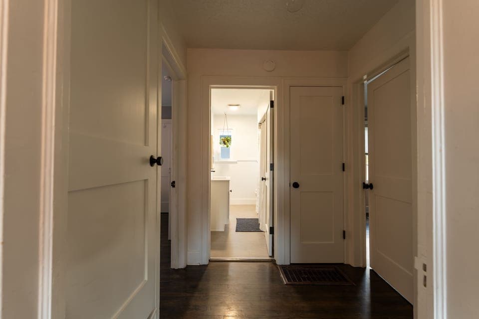 Central hallway connecting bedrooms and bathroom with warm natural light.