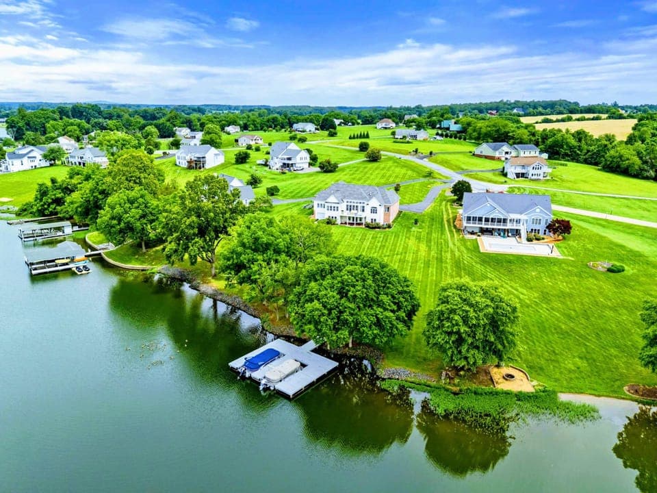 Aerial View - 220 feet of deep-water shoreline, a private two-slip dock, and a sweeping green lawn set the stage for lakefront living at its best.