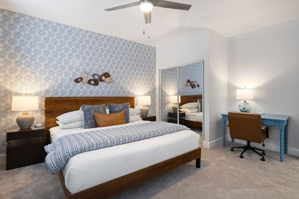 Elegant king bedroom with a chic headboard and a convenient work-from-home setup.