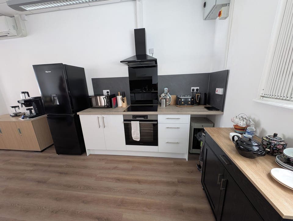 View of kitchen facilities - induction hob and electric oven, fridge freezer