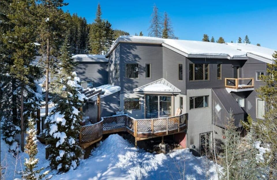 Stunning mountain property nestled among winter towering evergreens with expansive forest views and natural privacy.
