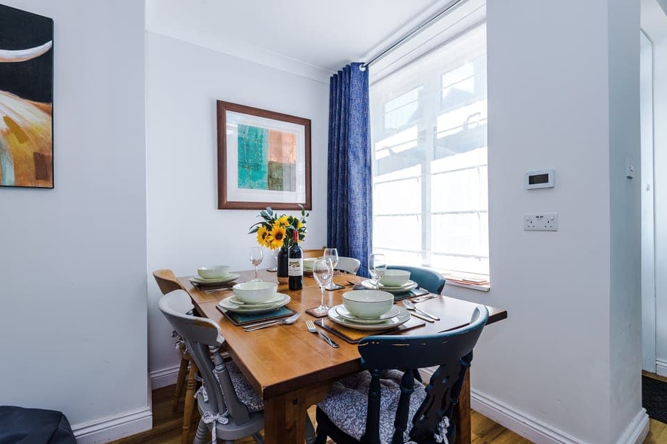 The open-plan dining area is seamlessly connected to the living room and kitchen, creating a sociable and spacious setting. Tucked by the window, the table seats six comfortably—perfect for enjoying relaxed meals with a homely atmosphere.