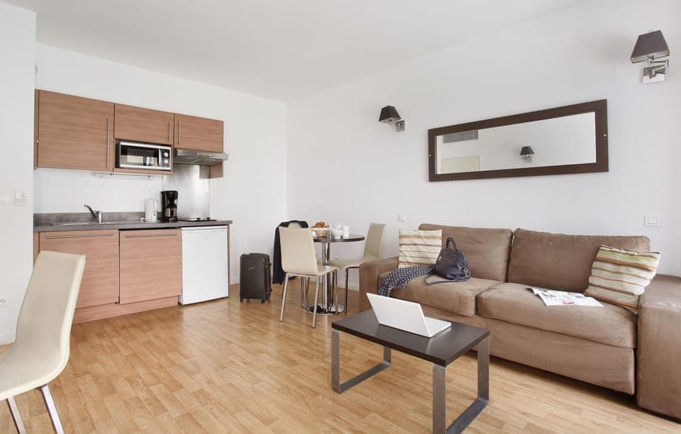 Open-concept lounge and kitchenette with sofa bed — perfect for unwinding after exploring Monaco.