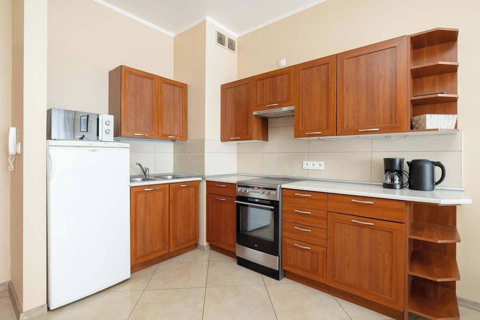A modern kitchen with brown-colored cabinets, an oven, and an induction stove.