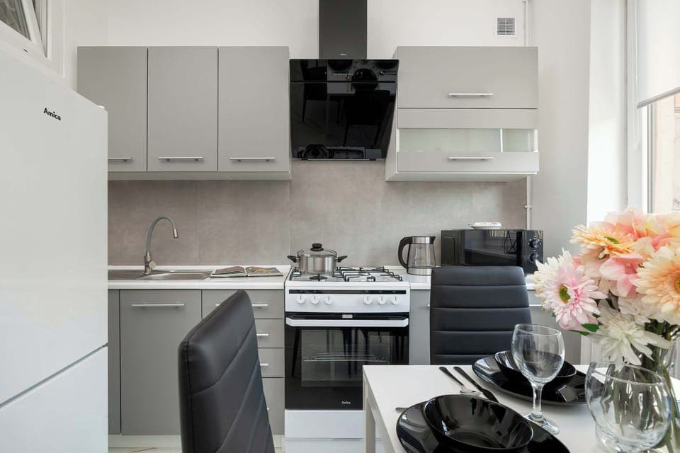Modern kitchen with grey furniture and quality appliances for a comfortable stay.