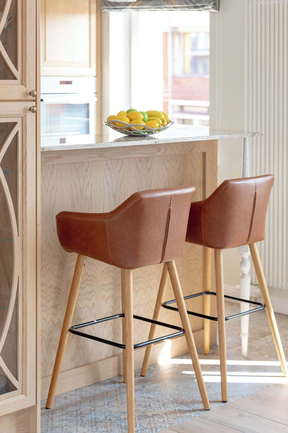 Tall bar stools stand at the kitchen counter.