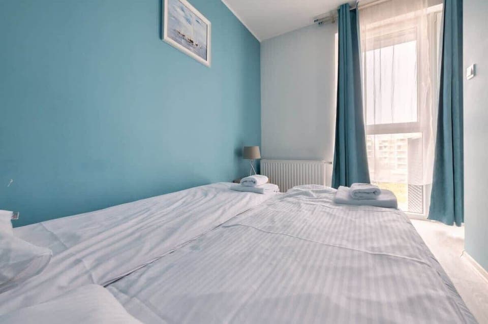  A large double bed with white linens beckons for a restful night, the lighting is provided by a lamp located opposite the bed.