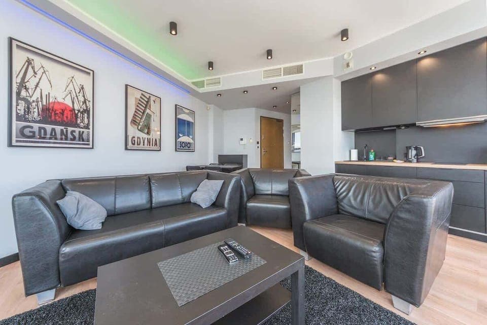 An elegant seating area with a minimalist coffee table and a flat-screen TV.