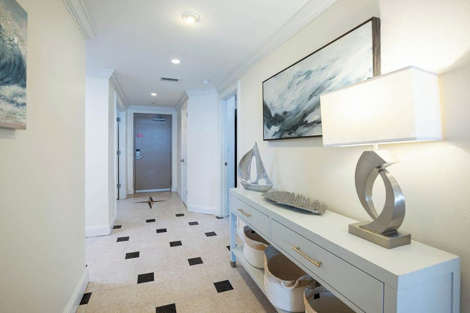Step into a welcoming hallway adorned with stylish decor, leading to your beachfront vacation retreat