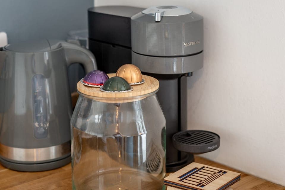 Coffee station with kettle, pods, and Nespresso machine