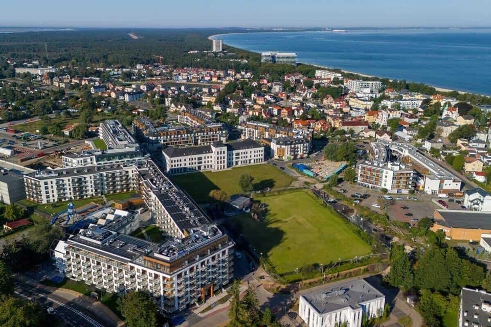 A detailed aerial perspective of a modern residential complex near the coast, emphasizing its prime location.






