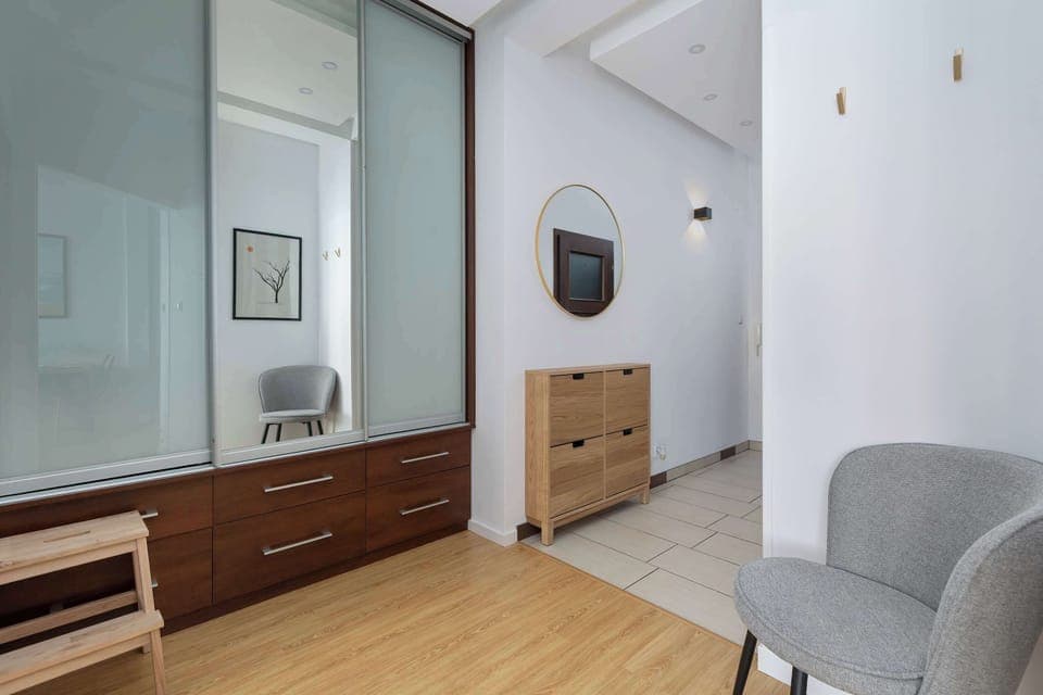 Hallway view with a dresser, mirror, and modern furnishings.