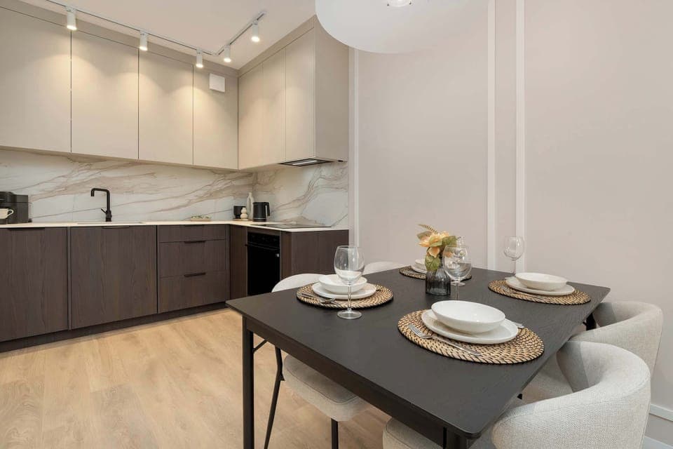 A modern kitchen with matte black cabinets and under-cabinet lighting. The layout is compact, practical, and stylish.