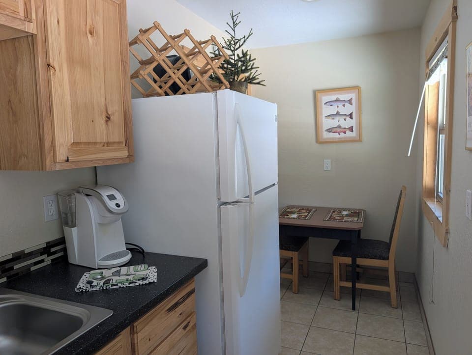 Refrigerator and Freezer, Dining area or work station, coffee maker in kitchen.