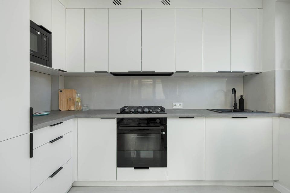 Fully equipped white kitchen with all essential appliances – A clean, functional space for cooking.