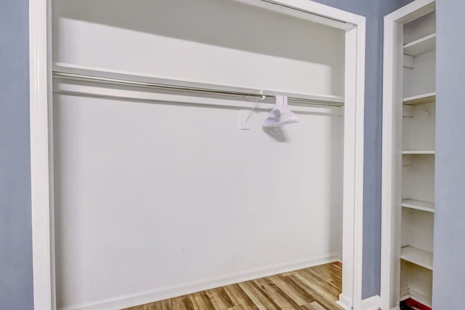 Spacious bedroom closet with hanging space and storage.