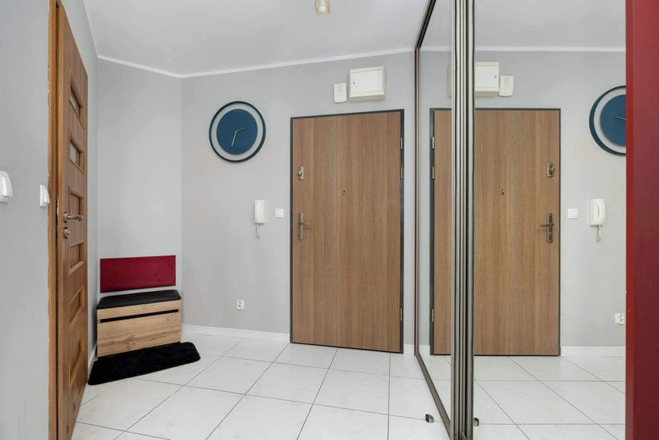 Hallway with closet and mirror.