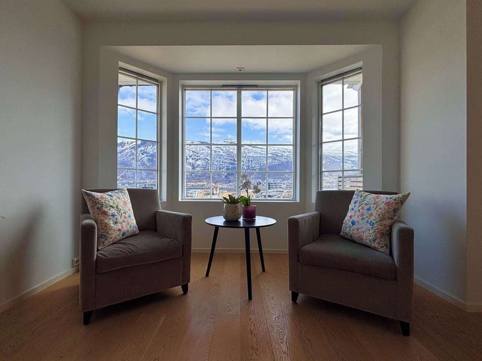 Cozy living room with a large sofa, perfect for relaxing after a day of exploring Tromsø.