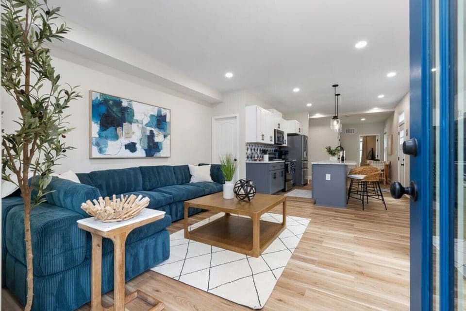 Bright open living space with high ceilings, sectional seating, and modern decor.