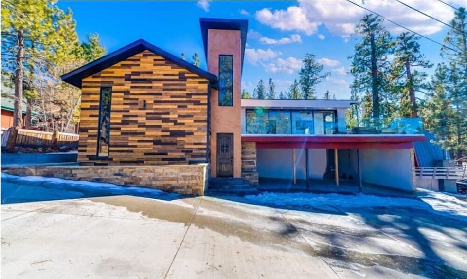 Welcoming cabin entry surrounded by towering pine trees, offering fresh mountain air and a peaceful forest setting—the perfect first impression for your Big Bear Lake getaway.