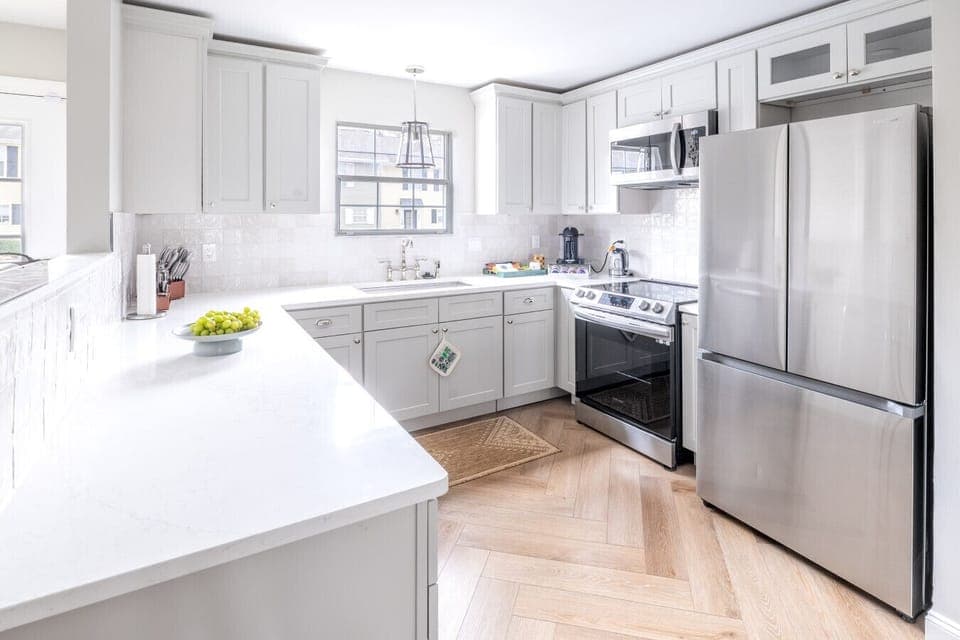 Gourmet kitchen with stainless steel appliances, gas stove, Nespresso machine, dishwasher, and full dinnerware/glassware for 12 guests.