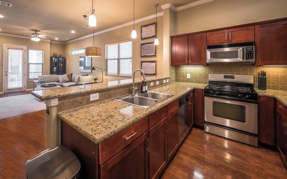 View of kitchen sink, dishwasher, oven, microwave