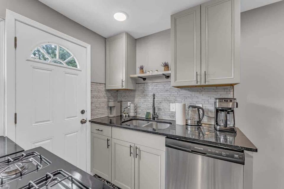 - Sleek kitchen with stainless steel appliances and sink   - Stylish backsplash with modern cabinets and storage   - Coffee maker and essentials ready for your stay  