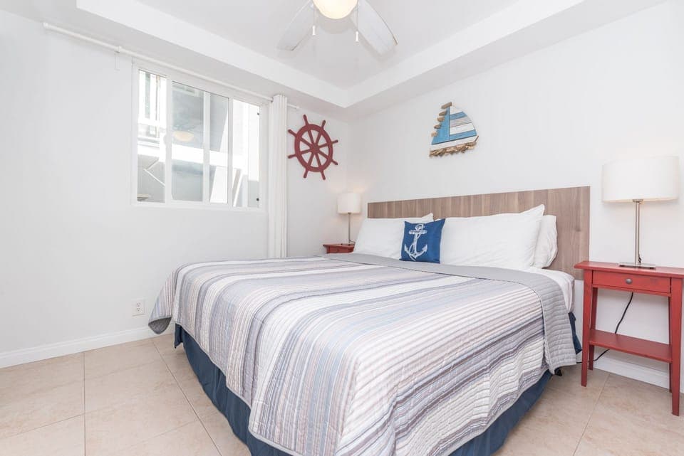This ground floor guest bedroom features coastal accents and a plush king-size bed
                