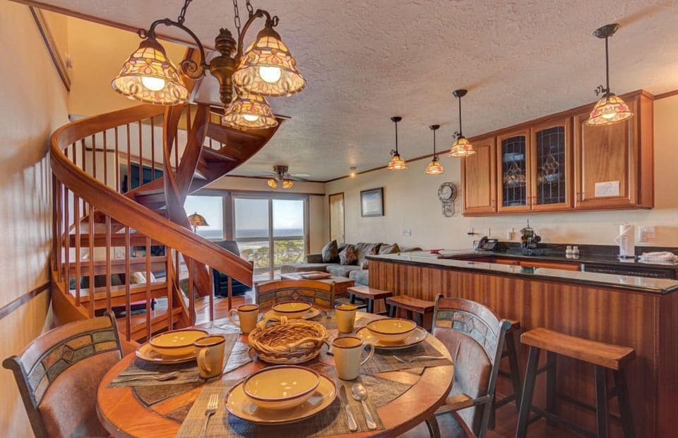 The dining area is inviting and perfect for family meals, featuring an elegant table set for gatherings and beautiful views of the ocean.