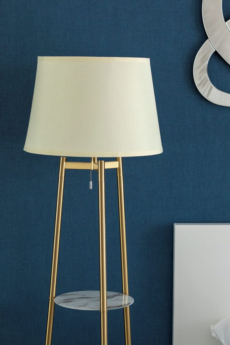 A cozy bedroom featuring modern artwork and warm tones. The stylish lamp adds a decorative touch.