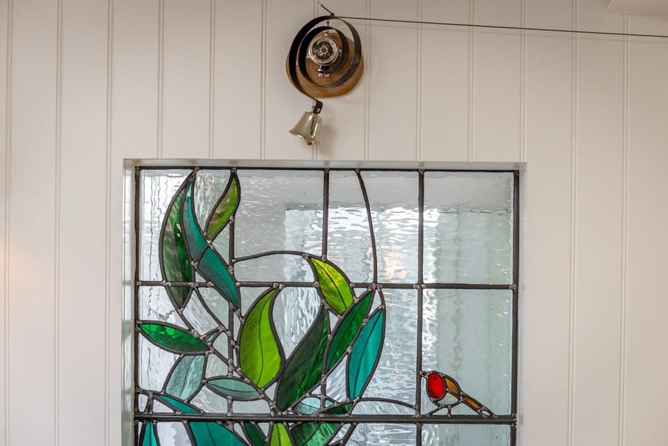 Decorative stained-glass panel with leaf and bird motif adding character to 42 Lade Braes, St Andrews.
