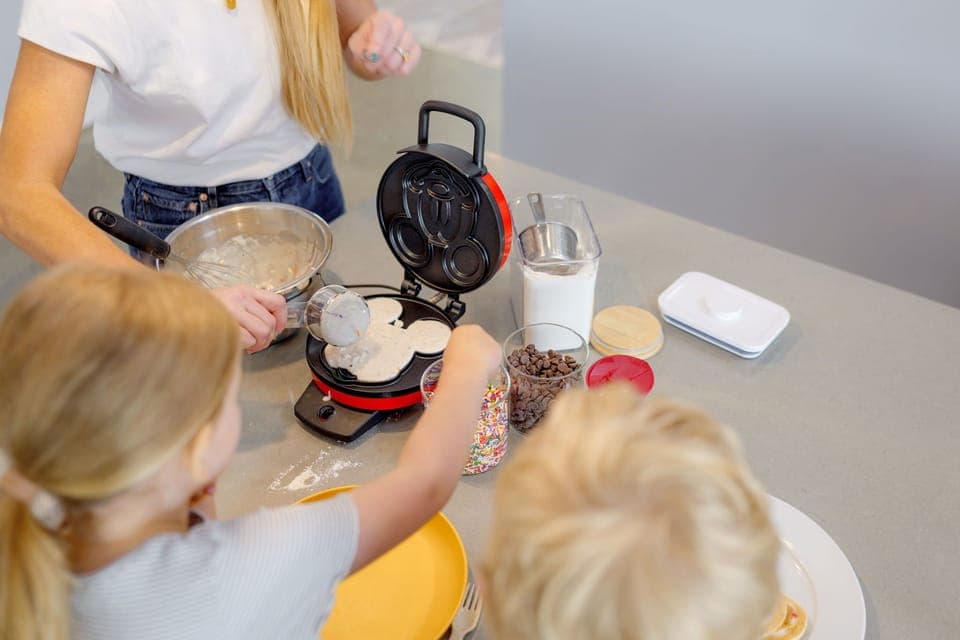 Mickey Mouse waffle bar with mix, toppings, and recipe card—fun for kids!