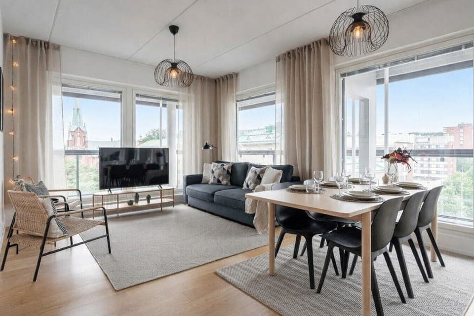 Relax in this bright, modern living room featuring large windows and a stunning view of the historic city church.