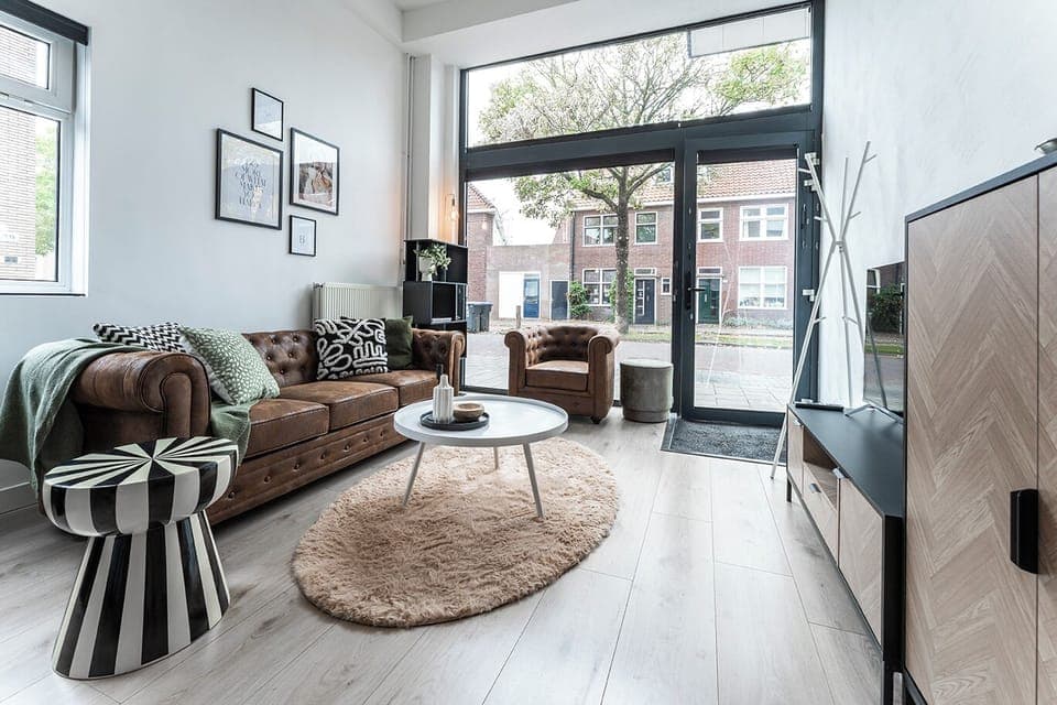 Loft-style living room with cozy seating, large windows & a chic industrial vibe.