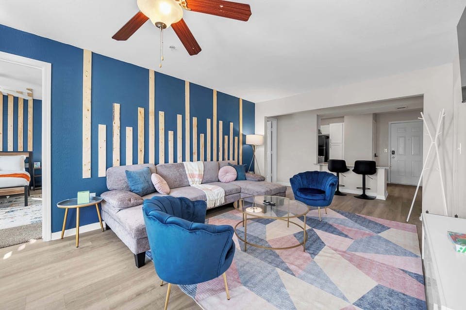 Bright living area w/ comfy seating & bold accent walls for easy relaxing.