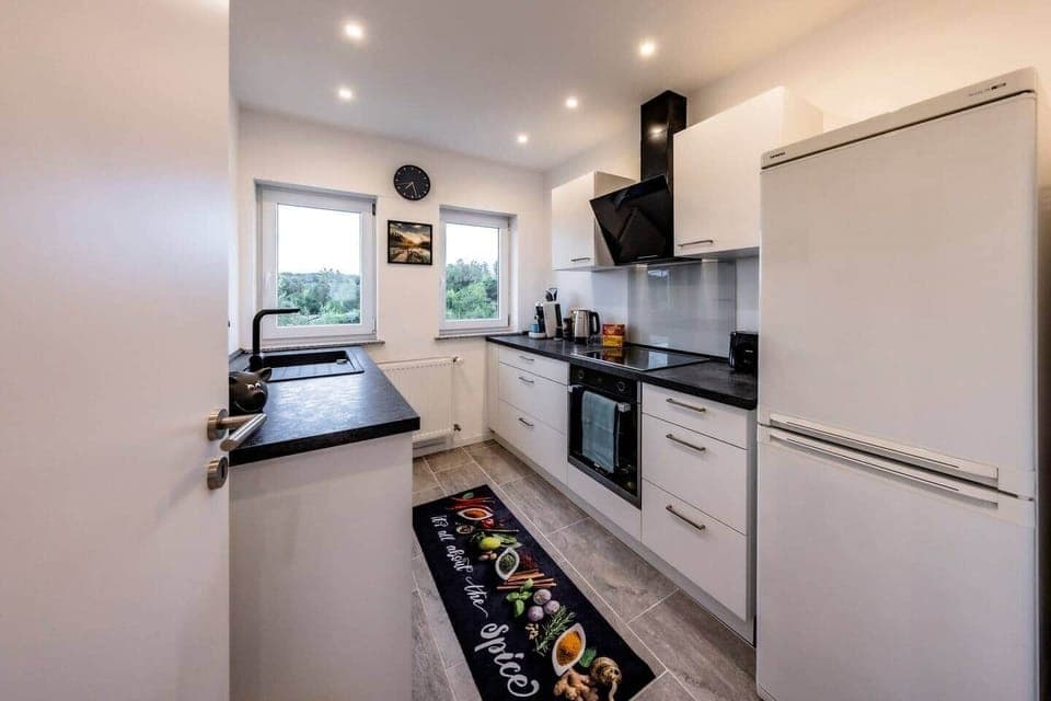 Fully equipped kitchen with modern ceramic hob, oven and extractor hood