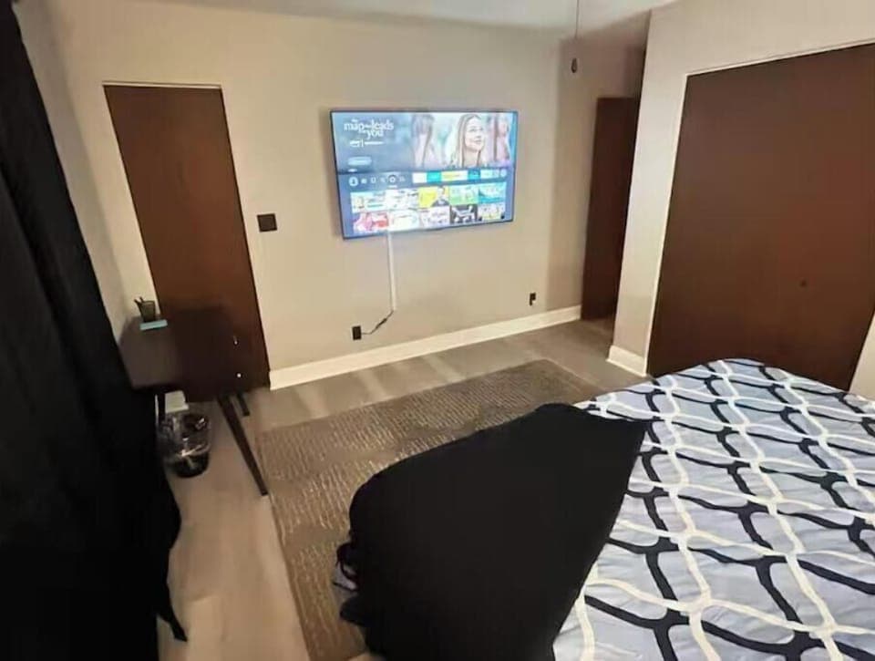 Master bedroom with king bed, smart TV, and private balcony.