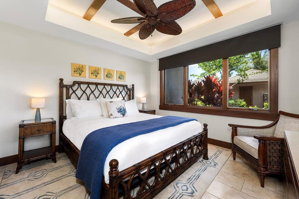 King guest suite with unique island furnishings and lush garden views at Laule'a #13.