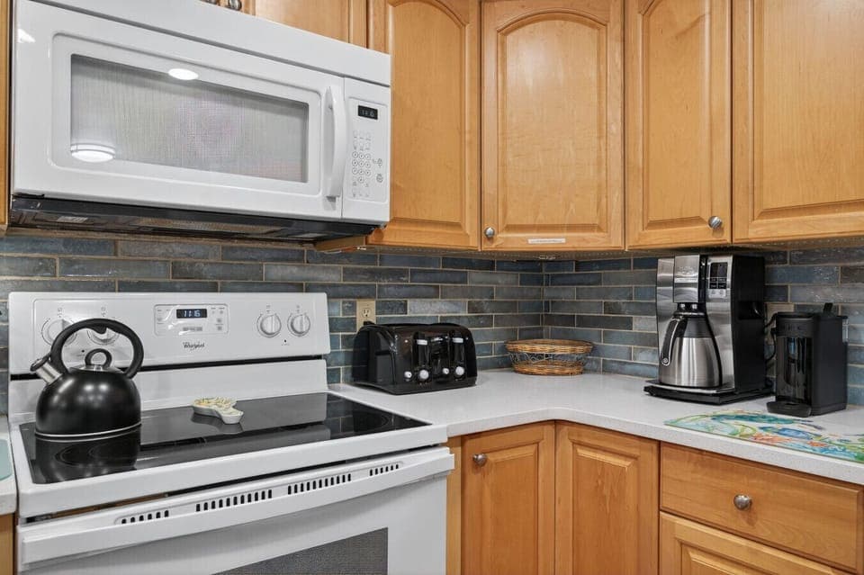 Kitchen cooktop & oven framed by warm wood cabinets and easy-to-clean counters.