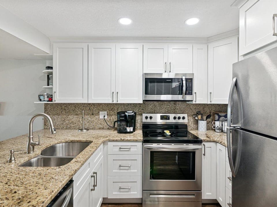 Next to the living area is a modern, fully equipped kitchen.