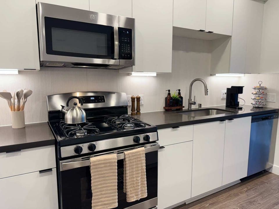 Experience extended comfort with a fully equipped kitchen featuring a coffee machine, stovetop, and microwave—everything you need for a seamless long-term stay.