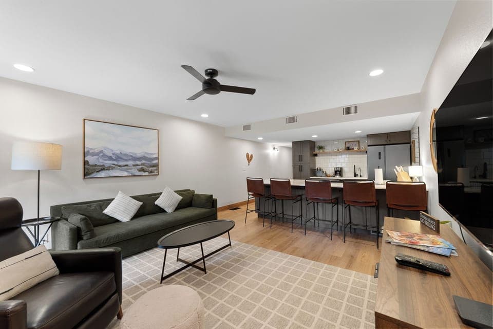 The cozy living area features a wood-burning fireplace, flat-screen TV, and access to the private balcony.