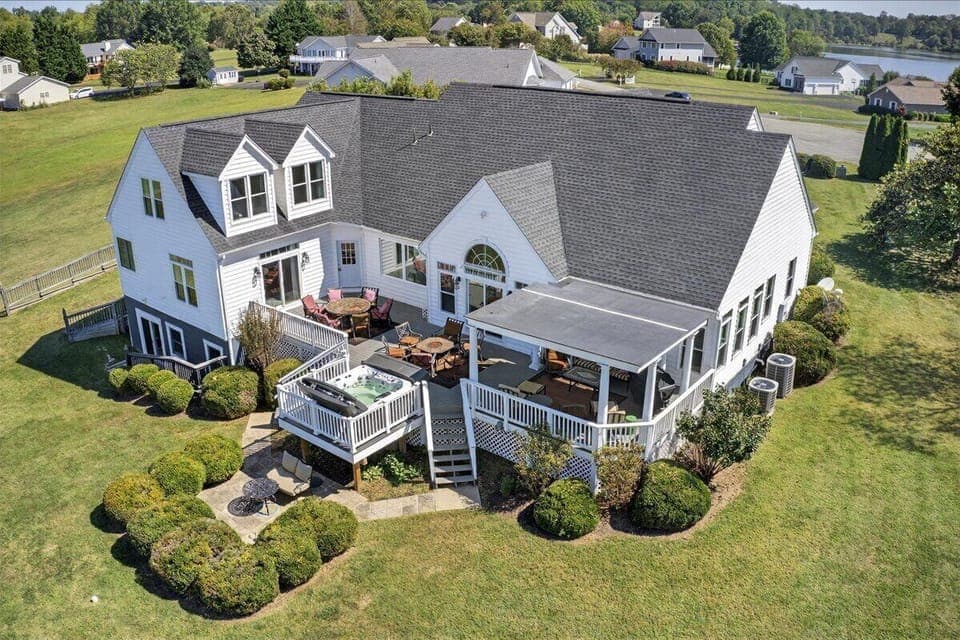 Bird’s-eye view of outdoor living: hot tub, dining, and lounge areas.