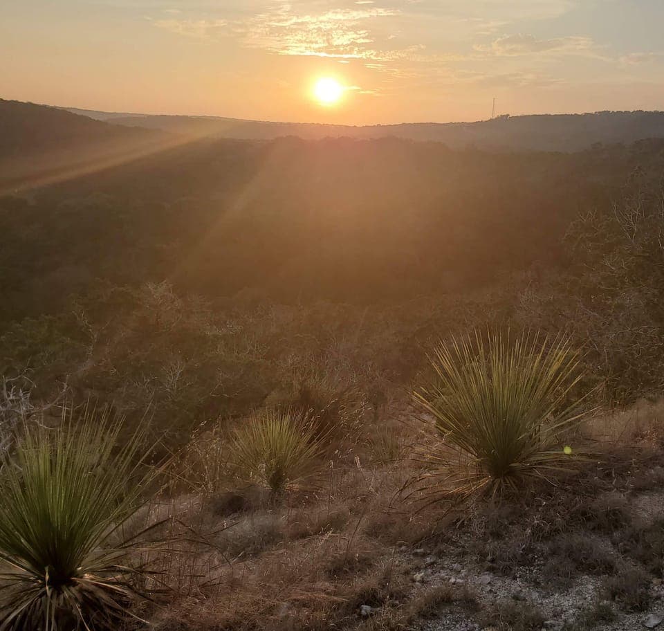 The Hill Country cliffs come alive at sunset, offering breathtaking views and a serene backdrop for the property.