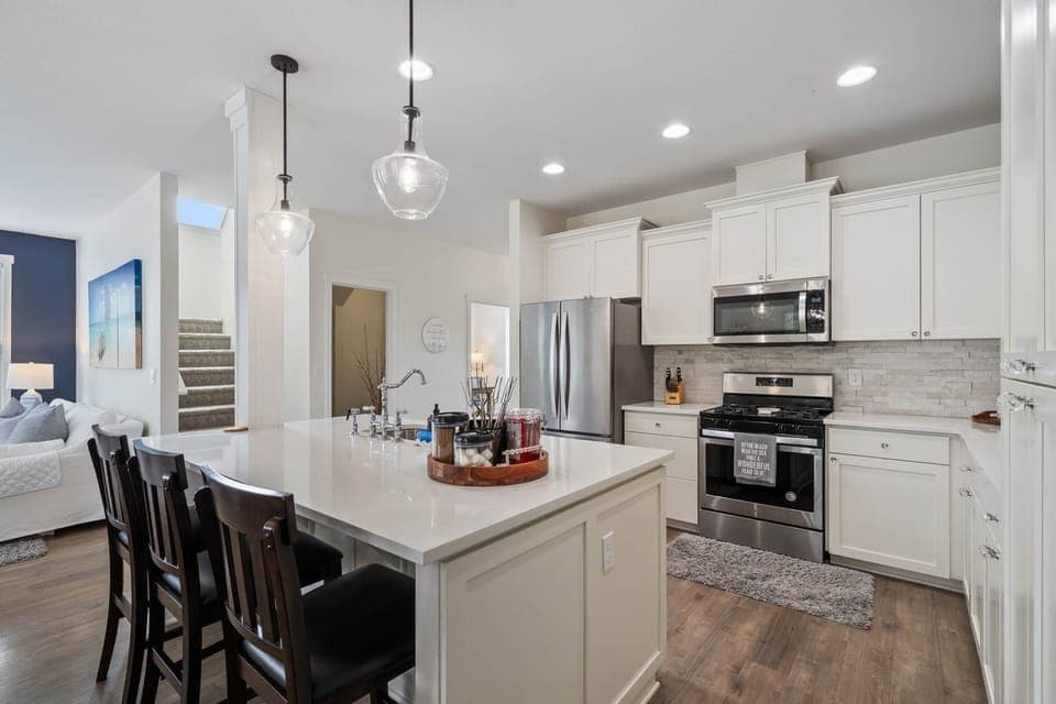 Large modern kitchen with quartz countertops, stainless steel appliances.