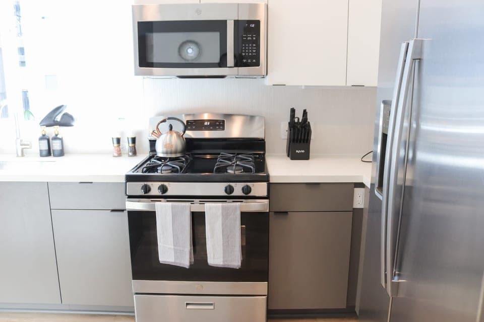 Experience extended comfort with a fully equipped kitchen featuring a coffee machine, stovetop, and microwave—everything you need for a seamless long-term stay